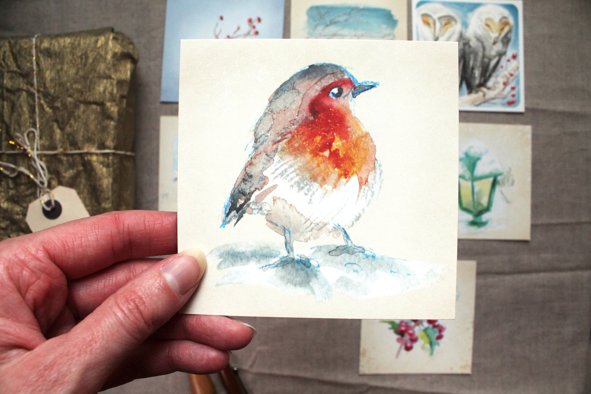 watercolour robin illustration on a card being held
